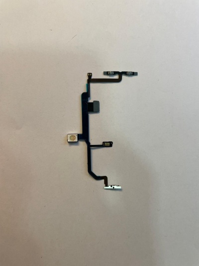 Flexível eletrónico preto com componentes metálicos numa superfície branca