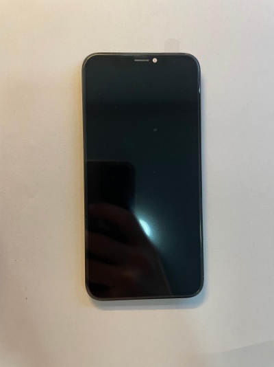 Smartphone com ecrã preto sobre superfície branca