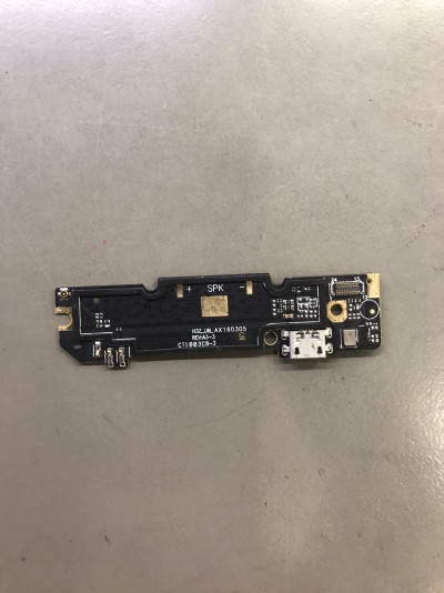 Placa eletrónica preta com conector USB branco sobre superfície cinzenta
