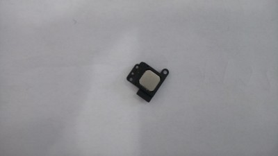 Peça eletrónica pequena preta com superfície metálica quadrada