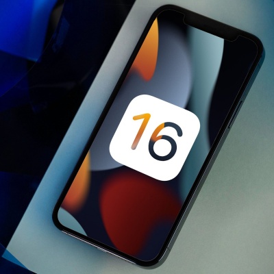 Smartphone preto mostrando número 16 no ecrã sobre superfície branca