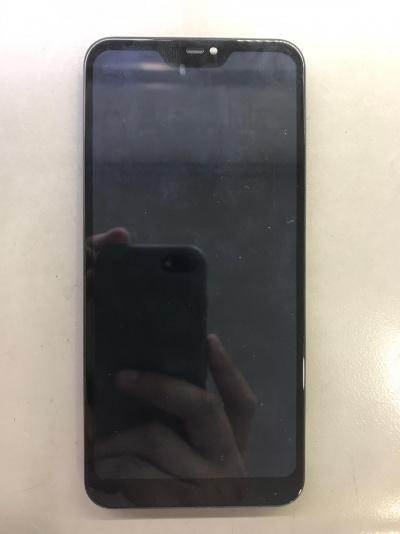 Smartphone preto com ecrã táctil sobre superfície clara