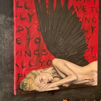 Quadro artístico com mulher deitada e asas negras, fundo vermelho com texto, em parede escura com ferramentas em baixo