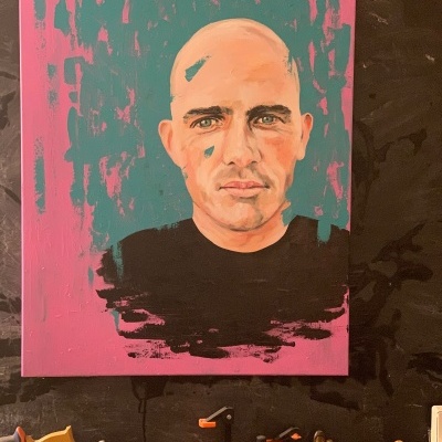 Pintura de retrato masculino sobre parede escura com ferramentas em superfície inferior