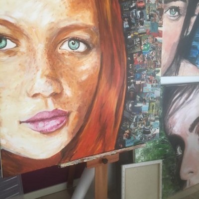 Pintura a óleo de rosto feminino ruivo com painel de pequenas imagens e outros retratos ao fundo