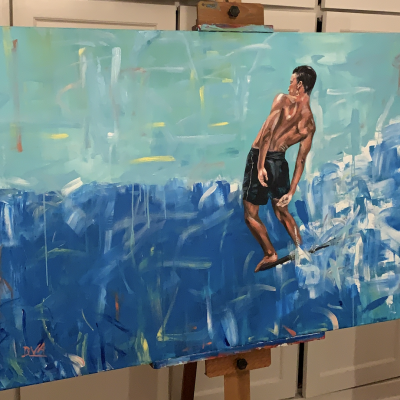 Pintura de homem a surfar em tons de azul e verde, sobre cavalete em madeira dentro de divisão