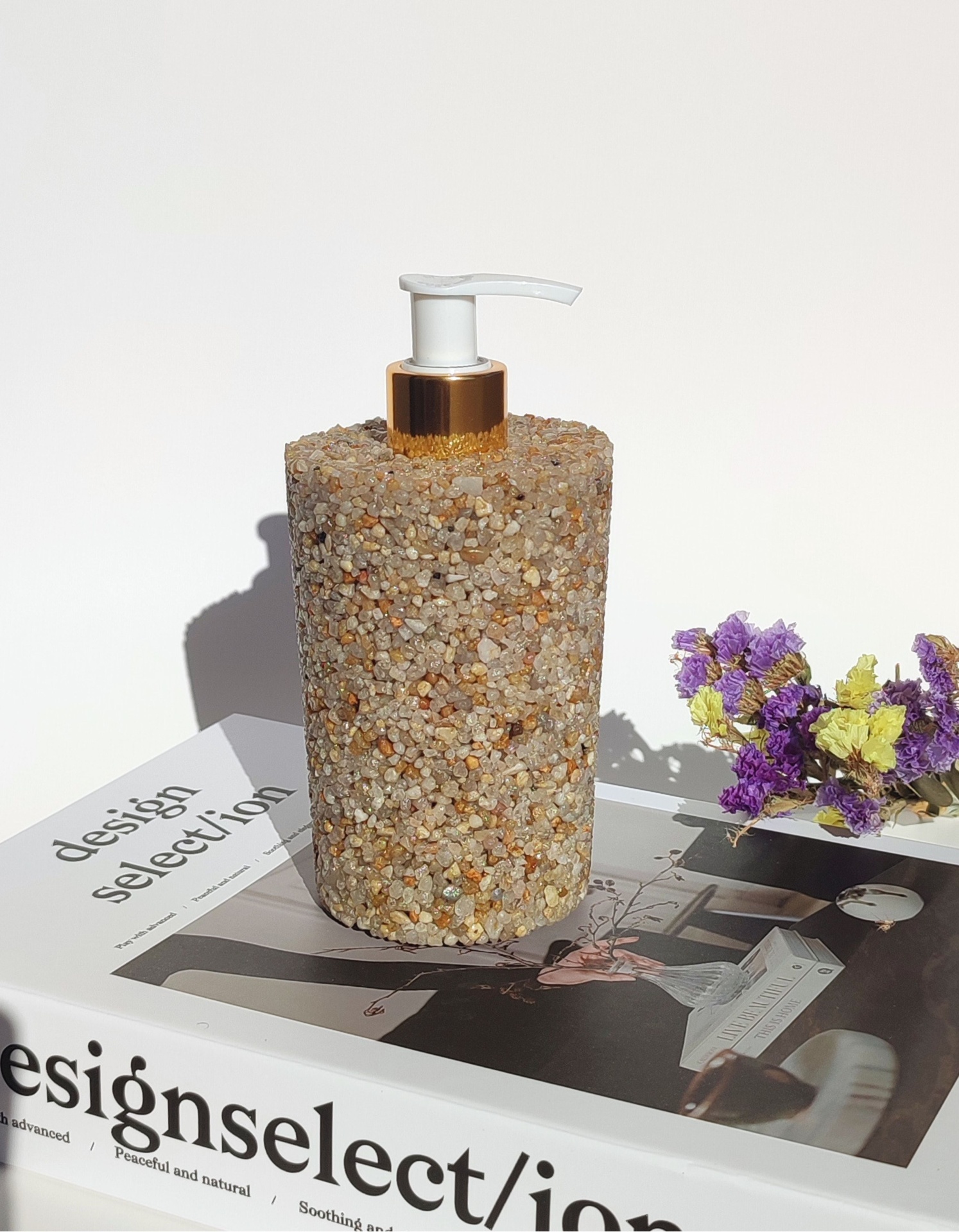 Dispensador de Sabão Pedra Natural S Dispenser de sabonete decorado com pedras sobre livros e flores secas