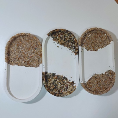 Três tabuleiros ovais com textura de pedras coloridas na metade superior