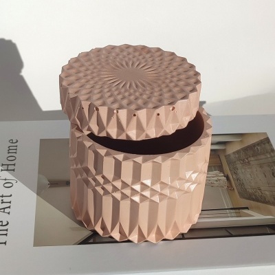 Caixa decorativa rosa geométrica em cima de livro The Art of Home