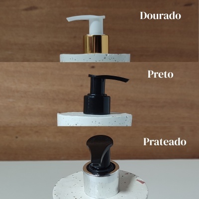 Tampas de dispensador dourado, preto e prateado sobre base branca com padrão pontilhado