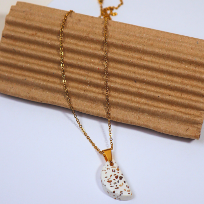 Colar com pendente semicircular branco com manchas castanhas e corrente dourada