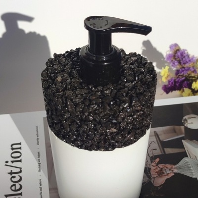 Dispenser branco com tampa preta texturizada e flores ao fundo