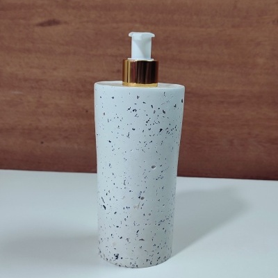 Dispenser branco com manchas pretas e tampa dourada