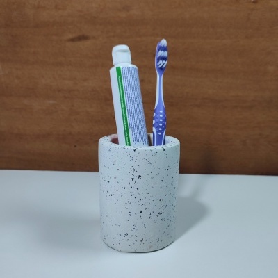 Porta-escovas de dentes branco em cerâmica com escova roxa e pasta dentífrica