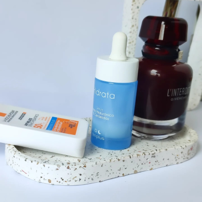 Três produtos cosméticos sobre base branca moteada