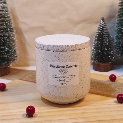 Pote de aspeto concreto com etiqueta e decoração natalícia