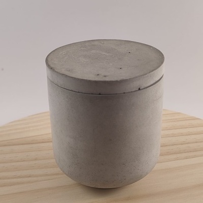 Recipiente cilíndrico cinza com tampa sobre madeira clara