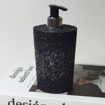 Frasco dispensador preto texturizado sobre livro branco com texto