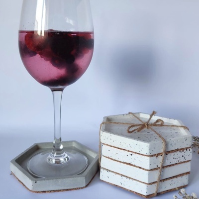 bases para copos de cerâmica branca e copo de vidro com vinho rosé