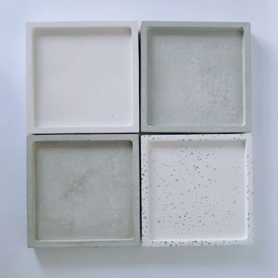 Quatro tabuleiros quadrados em tons de branco e cinza