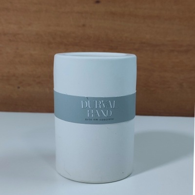 Frasco branco cilíndrico com etiqueta cinzenta e texto DURVAL RENO Arte em concreto