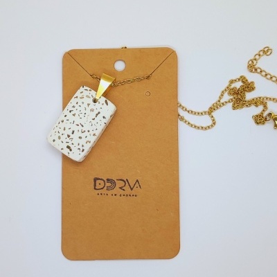 Colar com pendente retangular branco com padrão mármore e corrente dourada.