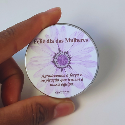 Lata redonda com decoração de flor lilás e texto comemorativo do Dia das Mulheres.