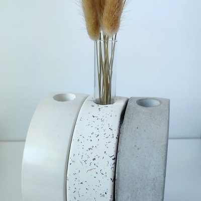 Três vasos cerâmicos tridimensionais curvos com flores secas em vaso de vidro