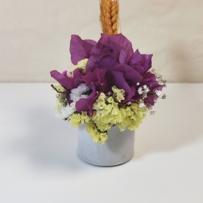 Arranjo floral em vaso branco com flores secas coloridas e espiga amarela