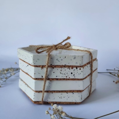 Conjunto de três placas hexagonais de cerâmica branca com manchas pretas atadas com corda rústica