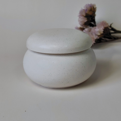 Frasco redondo de cerâmica branca com tampa arredondada e acabamento mate