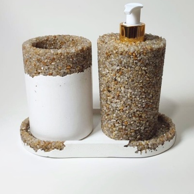 Conjunto de dispensador de sabão líquido e suporte revestidos com pedras decorativas e base branca.