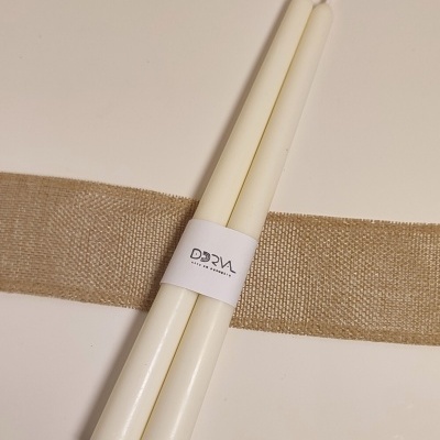 Duas velas brancas com faixa branca com texto DORAL ARTES EM CERÁMICA