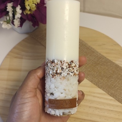 Vela branca cilíndrica com decoração de pedras e etiqueta de couro