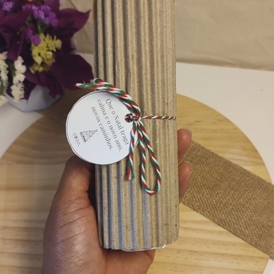 Embalagem de presente em papel cartão ondulado castanho com etiqueta redonda e fio tricolor