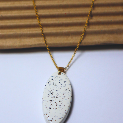 Colar com pendente oval branco com manchas pretas em corrente dourada