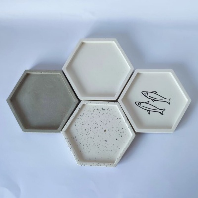 Quatro pratos hexagonais de cerâmica com diferentes cores e padrões