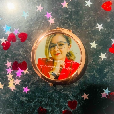 Espelho de bolso com imagem e texto decorativo rodeado de confetis coloridos