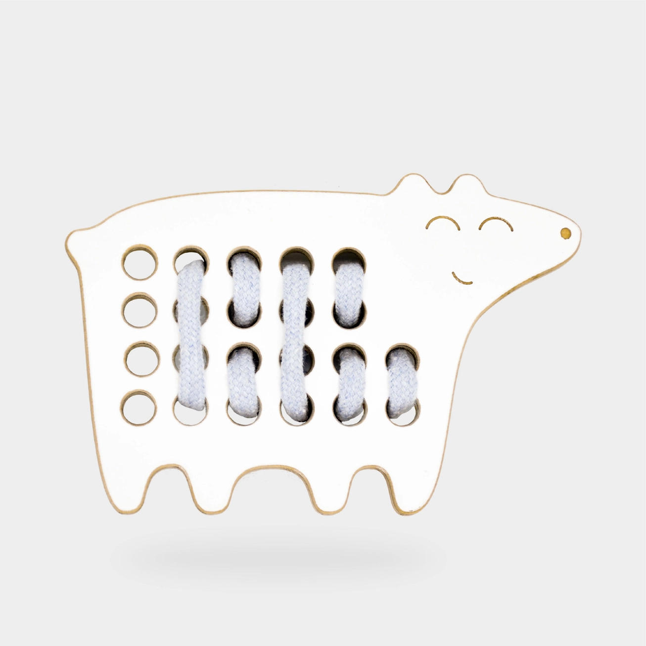 Brinquedo de madeira forma vaca branca com corda branca entre círculos