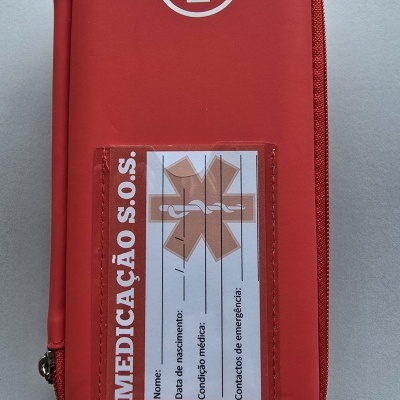 Estojo vermelho para medicação com cruz branca e etiqueta com campos para informações médicas