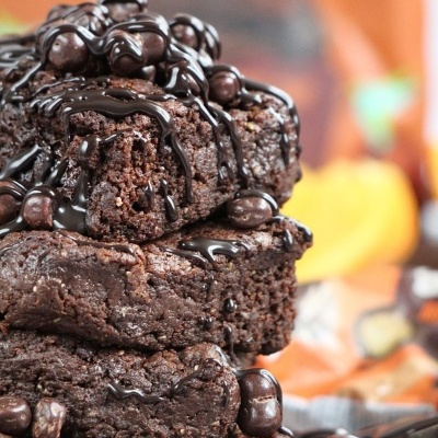 Quatro brownies de chocolate com cobertura de chocolate empilhados.