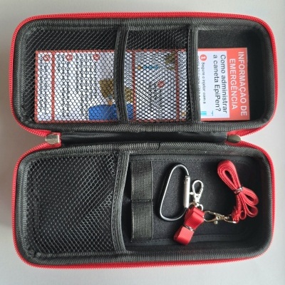 Estojo organizador preto com borda vermelha e acessórios dentro