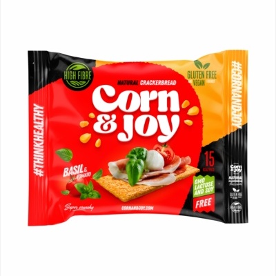 Embalagem de pão crocante natural Corn & Joy com indicação de ingredientes manjericão e tomate e texto sobre características do produto.