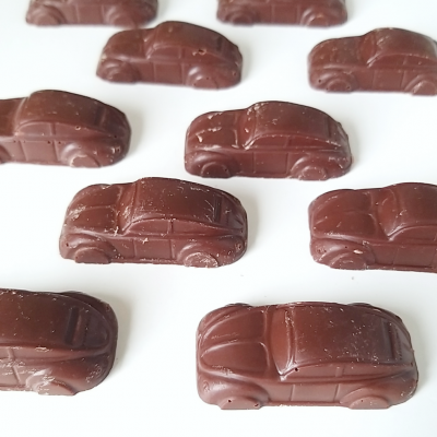 Dez bombons de chocolate em forma de carros clássicos castanhos escuros em fundo branco