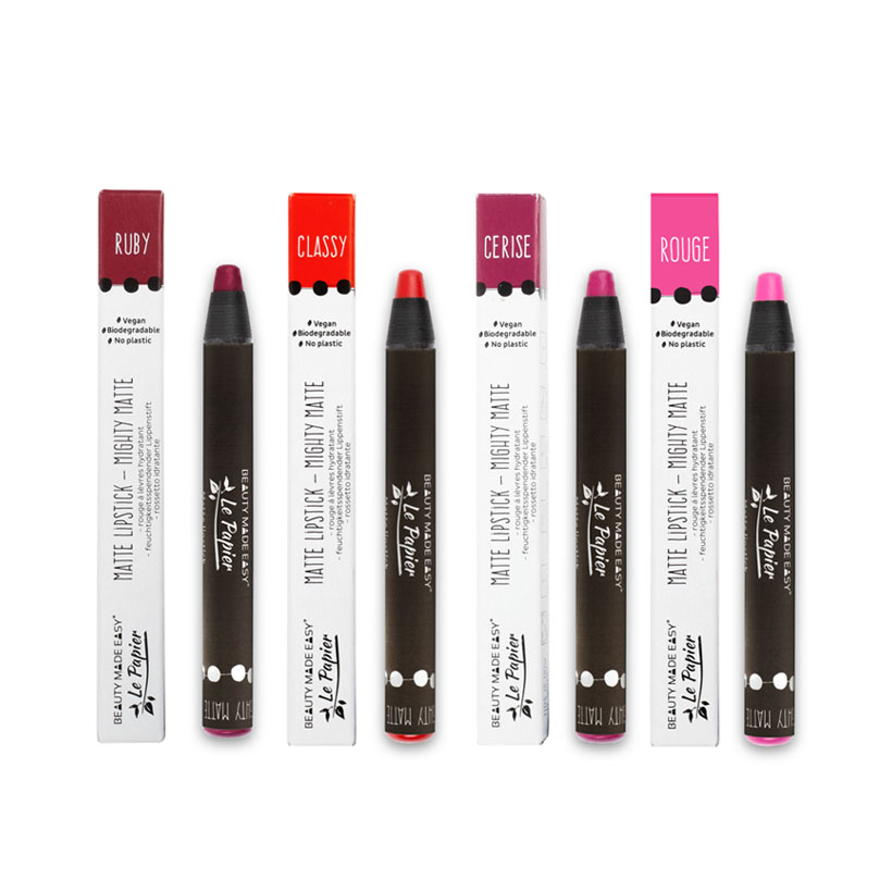 Quatro batons em lápis com embalagens brancas e corpo preto, com nomes RUBY, CLASSY, CERISE e ROUGE.