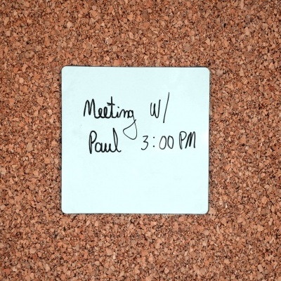 Nota adesiva azul claro com texto manuscrito numa cortiça