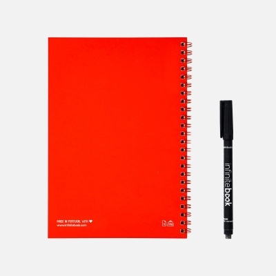 Caderno espiral vermelho com caneta preta ao lado em fundo branco