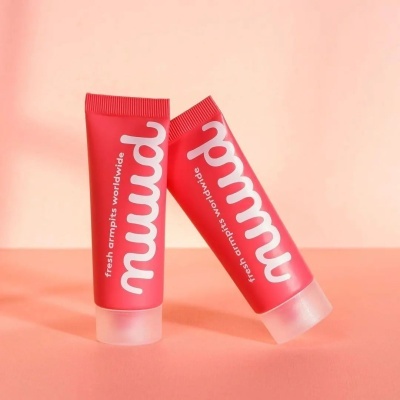 Dois tubos vermelhos de creme com texto branco 'muud' sobre fundo rosa