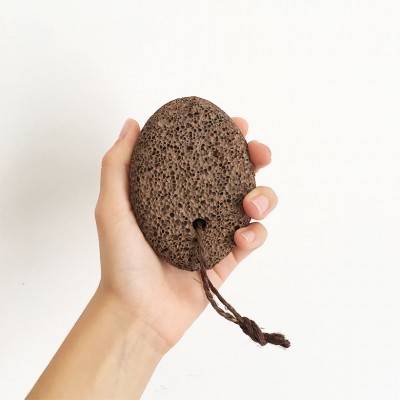 pedra-pomes castanha escura porosa com cordão, na mão