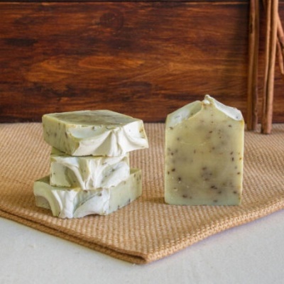 Sabonetes verdes claros com manchas escuras em superfície bege e fundo de madeira